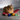 Orange cat sitting on a wooden floor with colorful Christmas decorations.