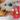 Cat playing with a red stocking filled with cat toys on a wooden floor.