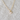 Cat Heart Necklace in white enamel and gold displayed on fabric