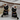 Drop earrings shaped as a black cat tangled in colorful Christmas lights and wearing a festive Santa hat.