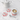 White teapot, cup with latte art, and red and white checkered coasters on a marble surface.