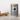 Two striped pet treat jars with paw prints on a wooden surface next to a colorful rope toy.