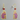 Purple and gold cat-shaped earrings with red beads on a white background