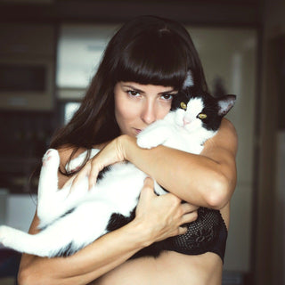 Cat lady holding a black and white cat, waiting to receive a cute cat themed gift!