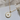 Gold necklace with a paw print pendant on a white box, brand 'Caramellsky' visible.