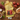 A yellow kitchen towel with a black cat sitting on a red armchair and the text 'try not to trip over my amazingness i left it everywhere' is laid flat on a wooden table, surrounded by food props including apples, grapes, peas, bread, onion, avocado, and nuts.