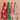 Four colorful kitchen towels with festive holiday prints hang from a wooden rack against a pink wall, with a wooden ladder holding another patterned towel on the left.