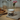 White mug with black cat design on a wooden table with pastries and jars in the background