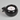 Black ceramic oil lamp with a lit white candle inside on a white background