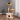 Cat tree with multiple levels and a cat sitting on top in a room with a gray wall and wooden floor.