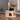 Cat sitting on a wooden cat tree with a wicker basket in a room.