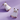A pair of white ghost-shaped stud earrings with gold trim and cat face details, displayed on a light purple background.