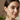 Woman wearing colorful earrings with a neutral background