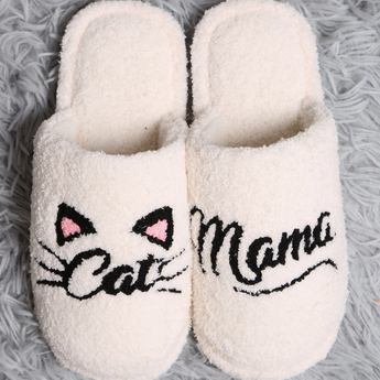White plush slippers with black 'Cat Mama' embroidery and cat ear details.