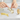 Gold dog-shaped cookie cutters on a white surface with hands interacting with them.