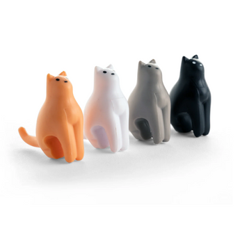 Set of four colorful cat-shaped tea bag holders in grey, black, white, and orange.