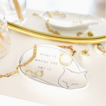 White ceramic cat trinket dish featuring the inscription 'Home Is Where The Cat Is'.