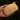 Wooden cardholder shaped like a cat face held in a hand with a blurred green background