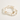 Three beaded stretch bracelets arranged in a circle on a warm off-white background. The bracelets are made of white and cream striped disc beads with small gold spacer beads, a gold cat-shaped charm, and one bracelet features white round beads spelling 'CAT MOM' with gold lettering.