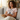 Woman sitting on a couch with a cat, wearing a 'CAT MOM' shirt.