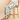 Person wearing colorful pajama pants sitting on a wooden stool against a beige background