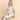 Woman wearing a colorful pajama set with a pattern on a beige background