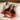 Woman wearing a red shirt and a sleep mask with a lion design, lying in bed.