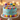 Colorful birthday cake with cat-themed candles on a blurred lights background