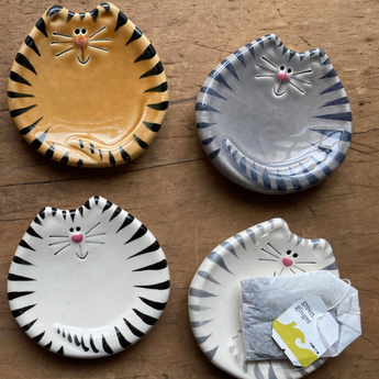 Cute ceramic tiger tabby cat dish with tea bags resting on it.