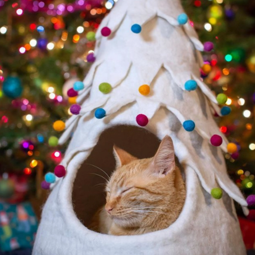 Cream-colored wool Christmas Tree Cat Bed with colorful pom-pom ornaments