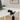 Black cat-shaped umbrella stand on a desk with a laptop