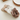 Set of three fluffy scrunchies in beige, white, and brown on a light surface.
