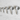 Five gray measuring spoons with cat-face details and measurement markings, arranged by size on a white marble surface.