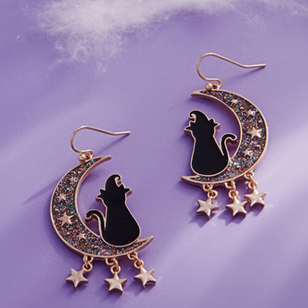 Close-up of black cat wearing witch hat on glittering crescent with gold-tone stars
