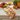A rectangular kitchen towel featuring a repeating Halloween cat pattern on a bright orange background, with cartoon cats in masks, hats, and costumes.