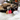 Cat playing with a toy on a soft surface with a blurred Christmas tree in the background