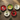 Five ceramic holiday bowls arranged on a rustic wooden surface, each featuring a different cat illustration in red, green, blue, black, and cream colors with festive accents like pine branches and small red ornaments.