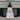A pink kitchen towel with a black neck loop, featuring a central graphic of a sleeping cat surrounded by a floral wreath and the text 'SHE BELIEVED SHE COULD BUT HER CAT WAS ASLEEP ON HER LAP SO SHE DIDN'T'.