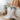 White socks with 'MEOW' text worn by a person sitting on a couch.