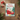 Christmas card with cats on a sleigh and 'Meowy Christmas' text, surrounded by festive decorations on a wooden surface.