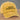 Yellow cap with 'my cat thinks I'm cool' text on a wooden surface