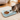 Cat drinking water from a blue pet feeder with two bowls in a home setting.