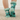 Teal socks with paw prints and fuzzy cuff worn by a person on a white background