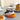 Set of three cat-shaped silicone egg rings in black, white, and orange, each featuring a curved tail handle, designed for making eggs and pancakes.