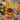 A rectangular towel, featuring a black cat peeking out from behind a dense pattern of colorful autumn leaves in shades of orange, yellow, red, and green.