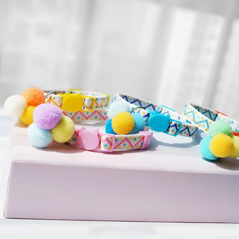 Close-up of Pink Pom Pom Cat Collar with purple, yellow, and blue pom poms.