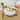 Cat lying on a round pet bed with a decorative background