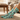 A single light blue crew sock with a western-themed print featuring cacti, cowboy boots, a cowboy hat, and a dog, shown on a white background.