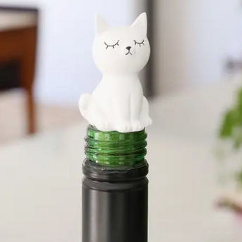 Ceramic white cat-shaped bottle stopper with highlighted eyes, nose, and mouth, perfect for sealing wine bottles with a touch of feline charm.