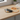 Smartphone on a wireless charging pad with an orange cable on a wooden surface.